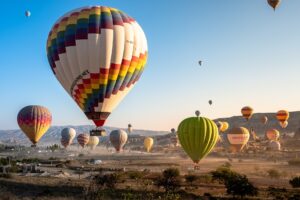 A collection of hot air balloons, all about to take off on a clear, sunny day.