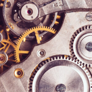 The internal workings of a watch, showing cogs and springs.
