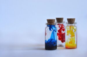 A picture of three small bottles, each containing a different colour poison