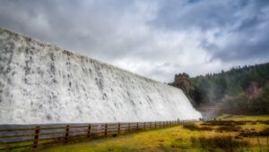 A picture of Derwent Dam, with water pouring over the top.