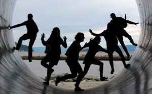 A group of people having fun in a giant tunnel outlet by the sea