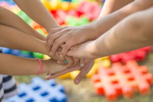 Hands, one on top of the other, a group of friends standing together