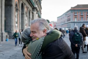 Two people hugging in a city square