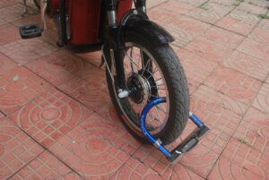 A bike with a lock on the front wheel, stopping the bike from moving forward