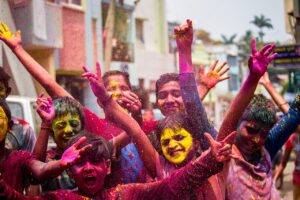 Young people, covered in multicoloured dye, celebrating life.