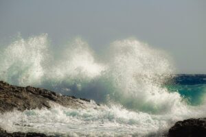 The uncontrolled power of waves breaking against rocks.