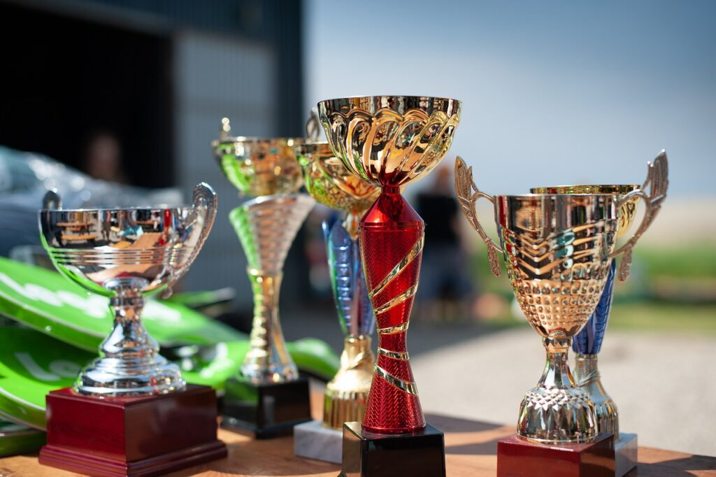 A collection of brightly lit and colourful trophies. These are for winners.
