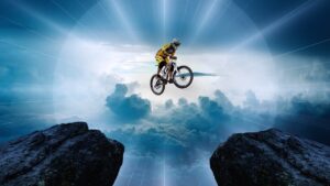 A person on a mountain bike leaping across two peaks, backlit by a stunning sun. An image of hope and excitement.