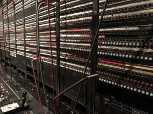 A picture of an old-fashioned switchboard with lots of cables, some crossing each other. It all apears very chaotic, a sign of what happens when we miscommunicate