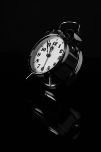 An alarm clock, in black and white. seemingly falling