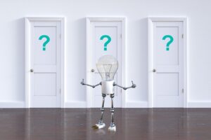 Three white doors, each with a turquoise question mark on them. A human figure made out of a light bulb and wire, is wondering which option to take. Will they light up when they make a choice?