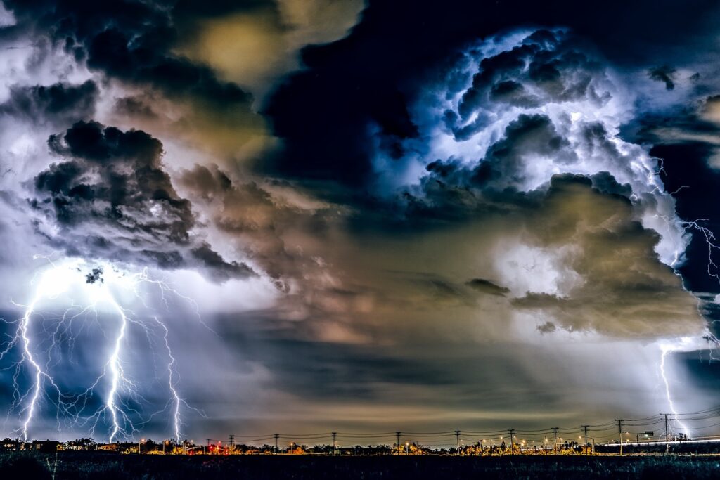 A thunderstorm over a city. The clouds are dark and menacing, with multiple lightening strikes.
