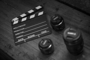 A black and white photo of a clapper board and three different lenses. It's time to take action.