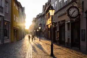 A family walking along a cobbled street as the sun goes down.