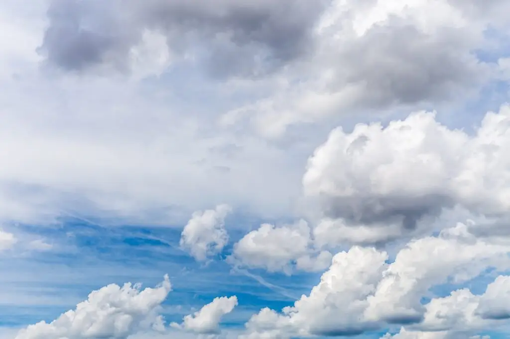 A blue sky with mostly white clouds drifting by, much as sleep allows us to drift off into another world