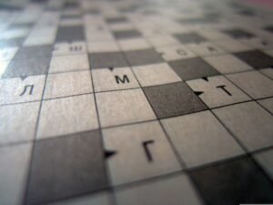 Close-up of a printed grid with square tiles and Cyrillic letters, photographed at an angle (blurred).